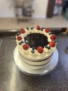 White frosted cake topped with fresh berries